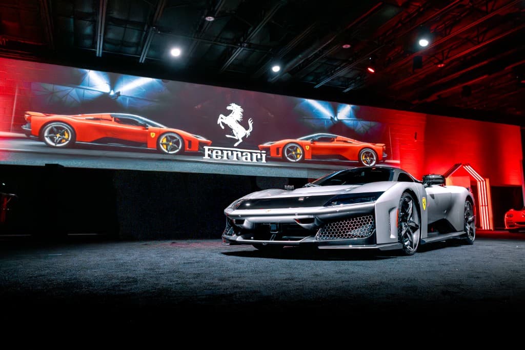 Corporate reveal event featuring a premium vehicle with wide-format LED display and theatrical lighting.