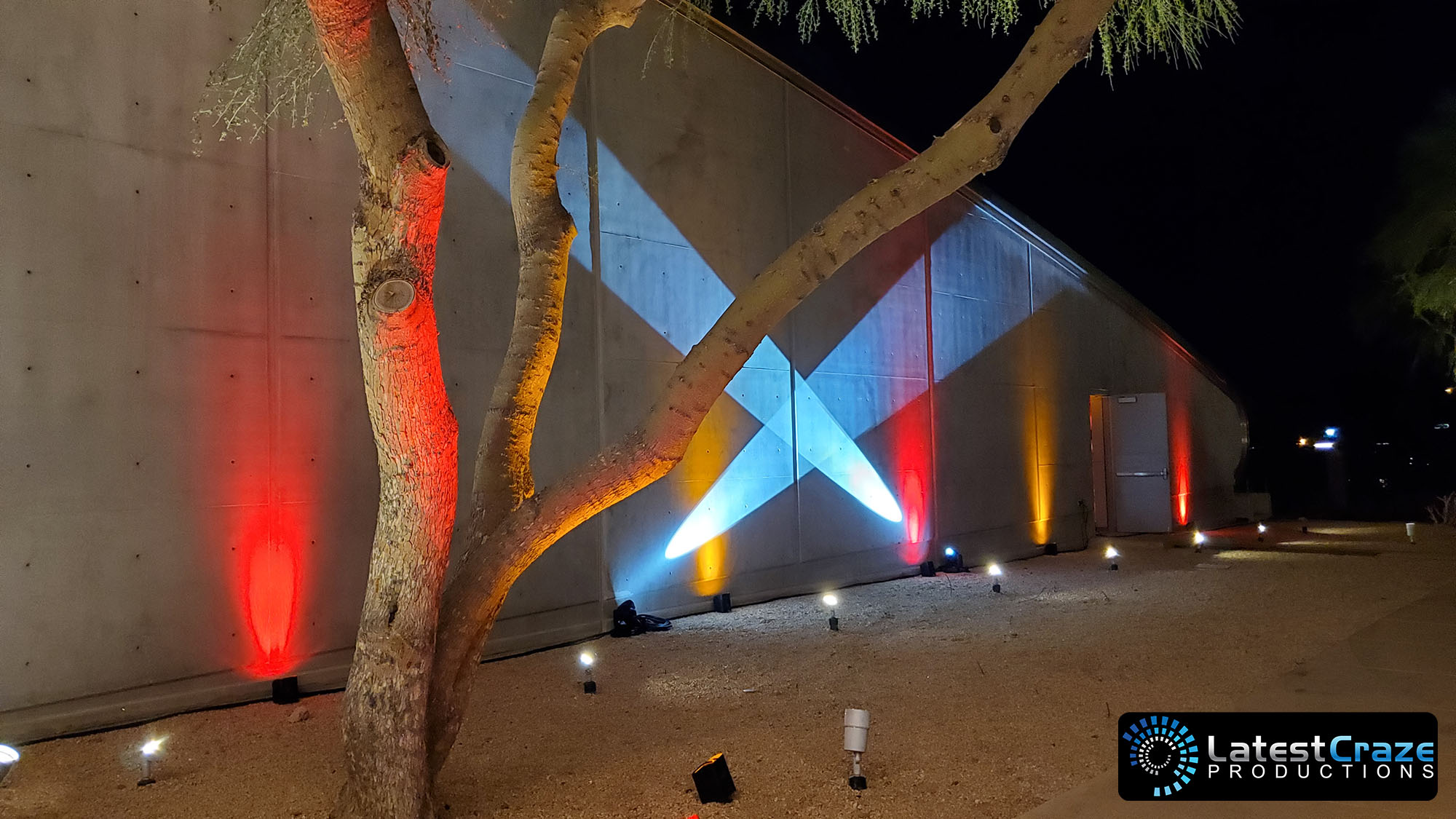 search lights on wall behind tree at entrance hangar one latest craze productions 030723